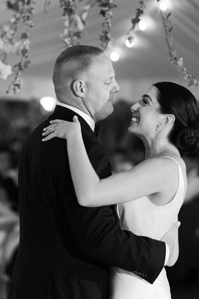A timeless black-and-white moment of the newlyweds sharing their first dance, with the bride smiling joyfully as she gazes at her groom. Captured by Claudia Amalia Photography, a Florida Keys wedding photographer specializing in destination wedding photography.