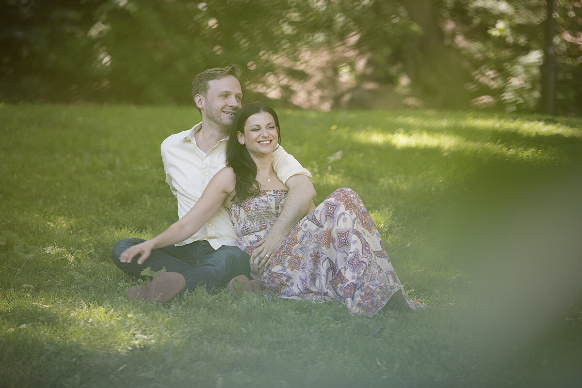 A couple sitting in a grassy area together
