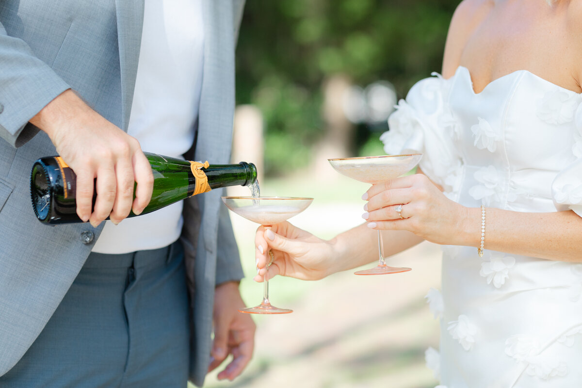 Couple pouring champagne in heirloom cocktail glasses during their engagement session