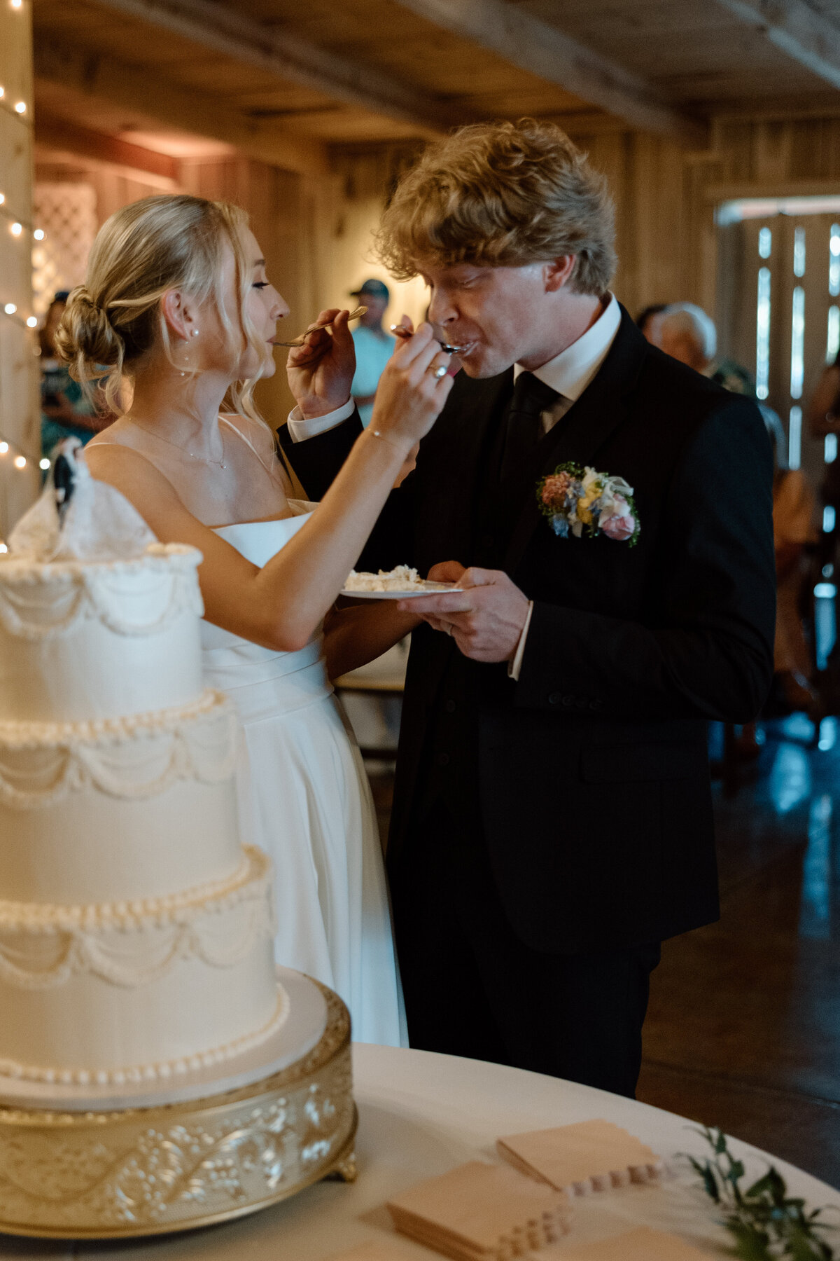 Bride and groom cut their cake and feed each other