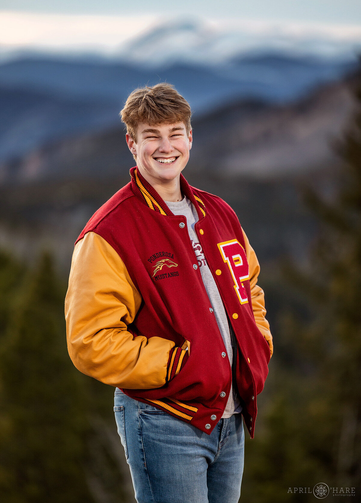 Letter Jacket Senior Photo with Mountain Backdrop in Evergreen Colorado