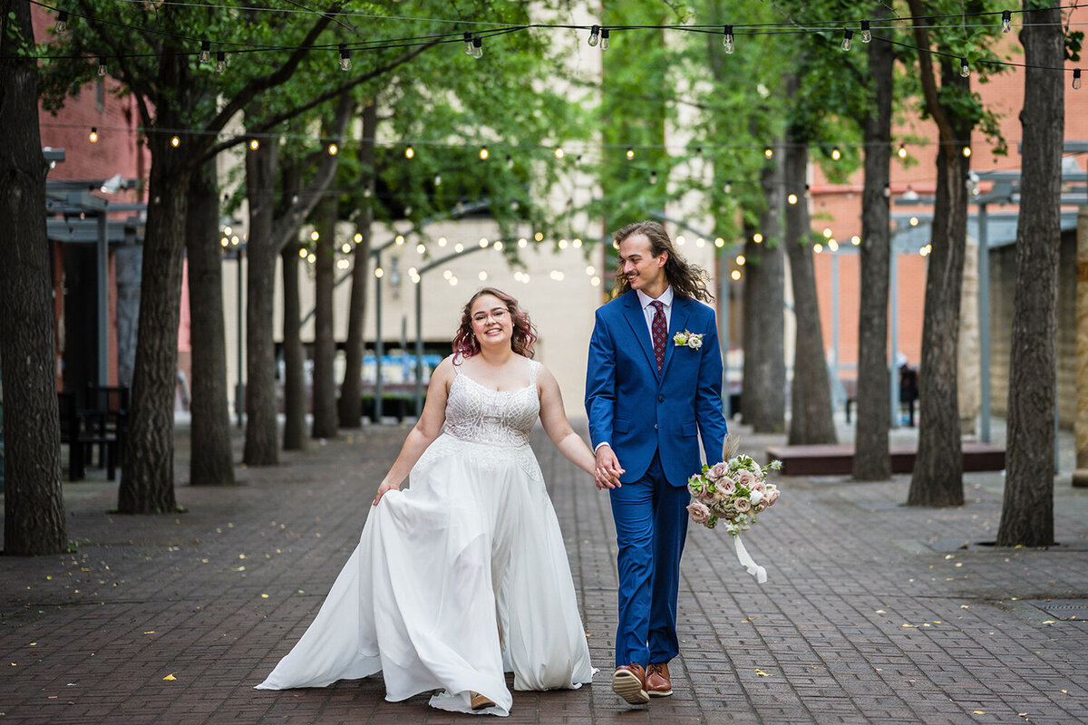 A bride and groom walk hand-in-hand in Downtown Roanoke  on their elopement day.