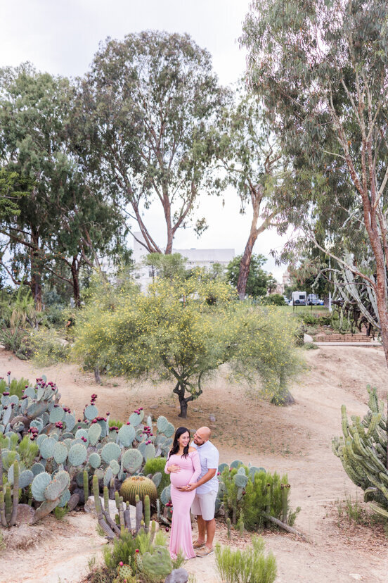 man and pregnant wife in balboa park cactus garden san diego