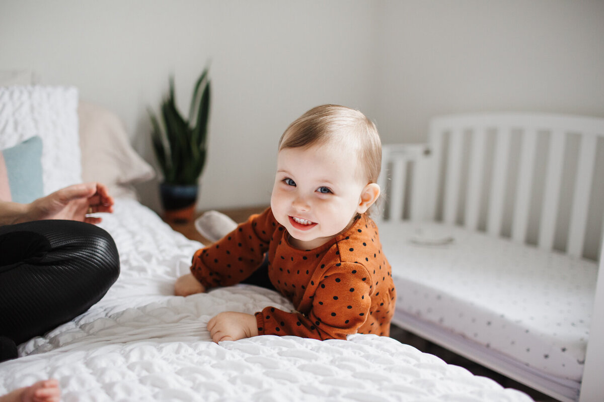 toddler girl climbing on bed