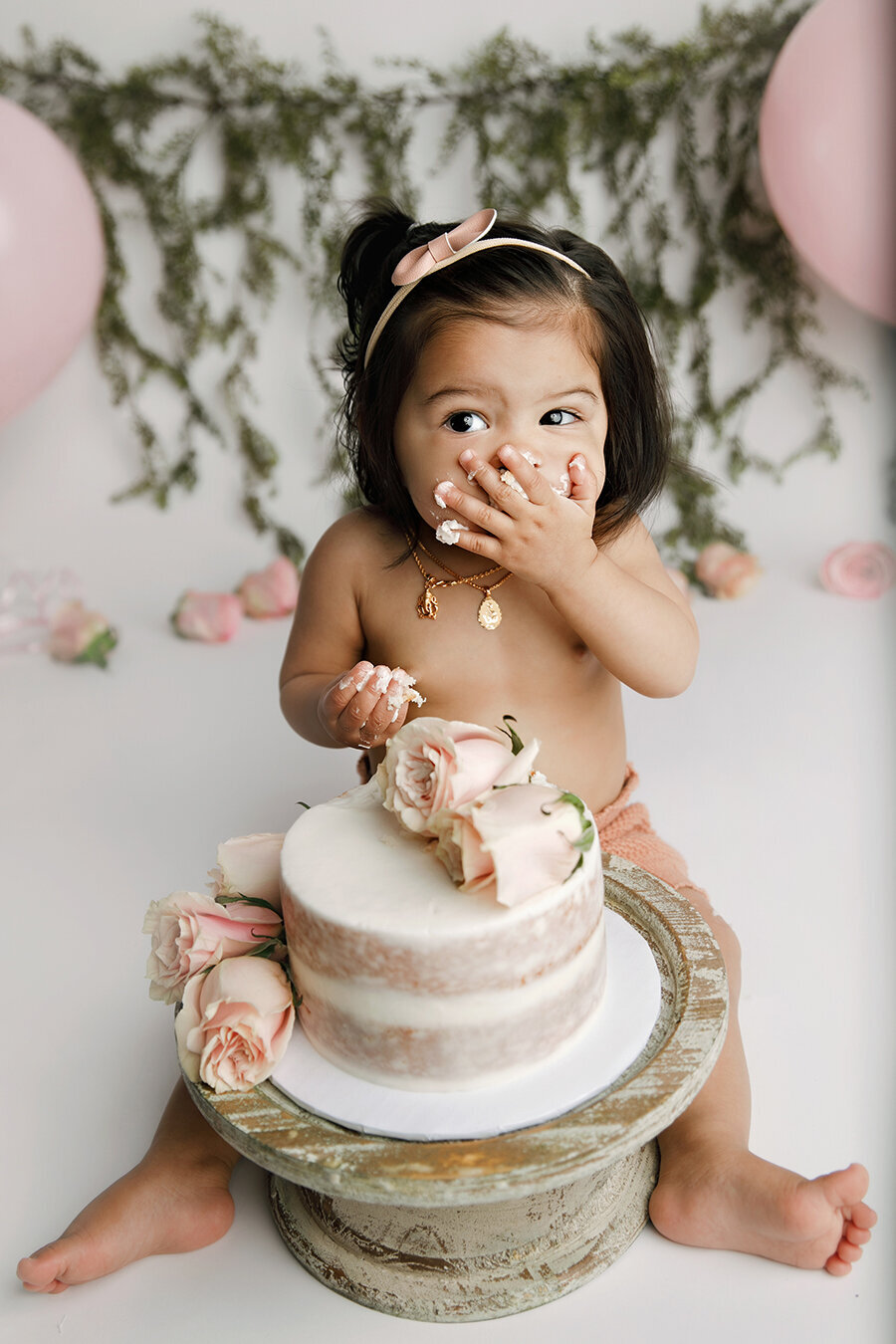 Fort Collins baby with her hand smashing cake in her mouth