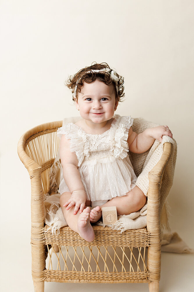 babyoneyearoldinwickerchair