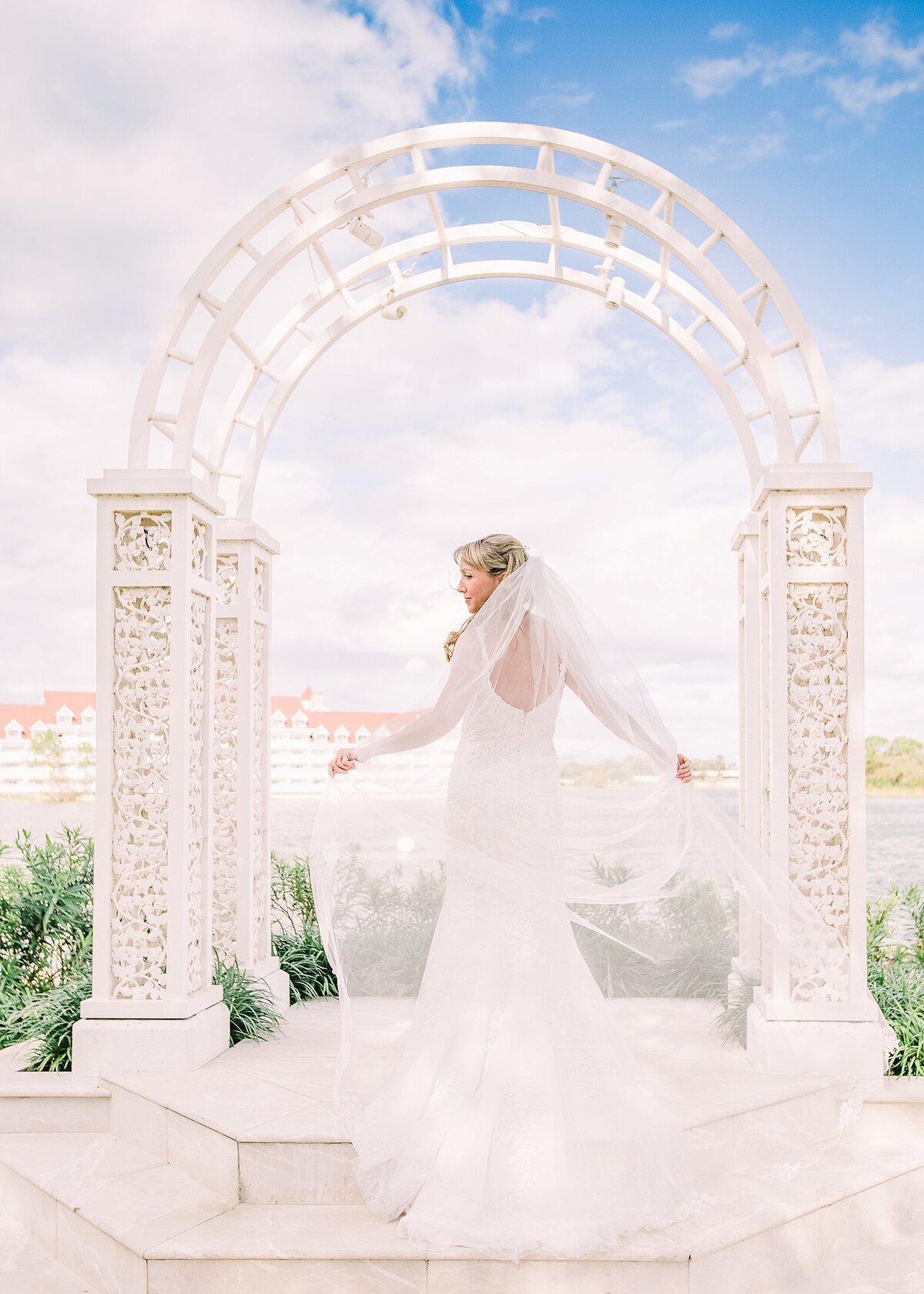 Bride is posing under the arch at Disney's Wedding Pavilion