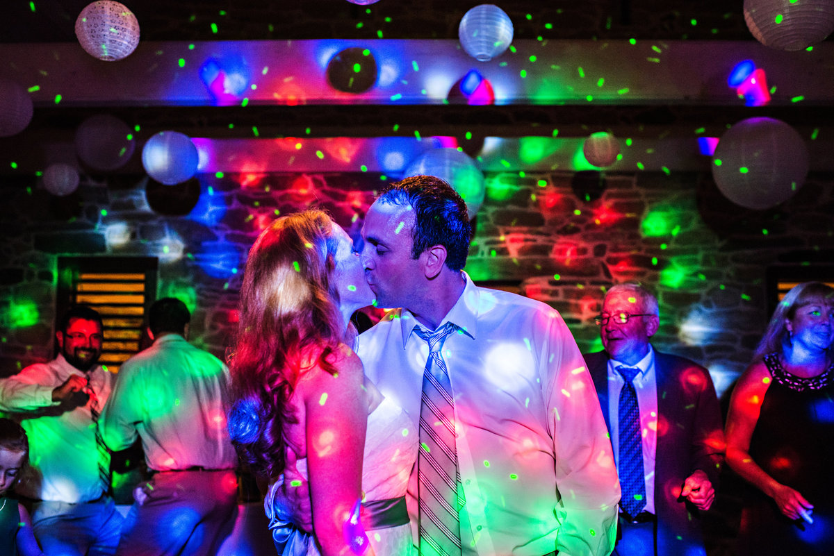 A newly married couple make out on the dance floor of their reception at Pheasant Run Farm in Lancaster, PA.