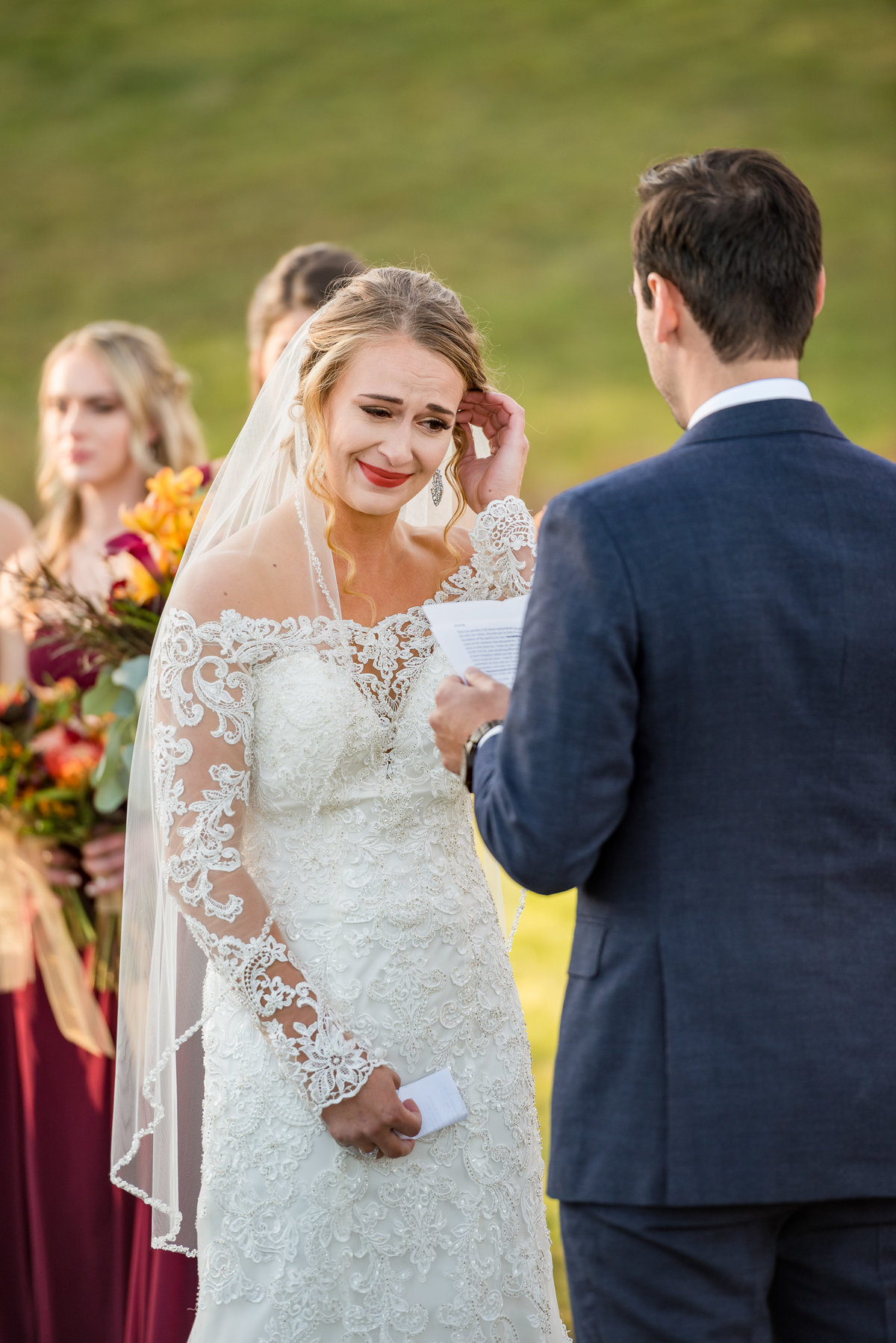 bride crying and wiping away tear during ceremony