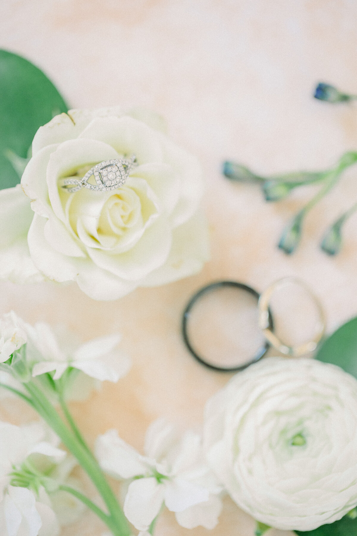 Bride and Groom rings surrounded by beautiful white florals and greenery