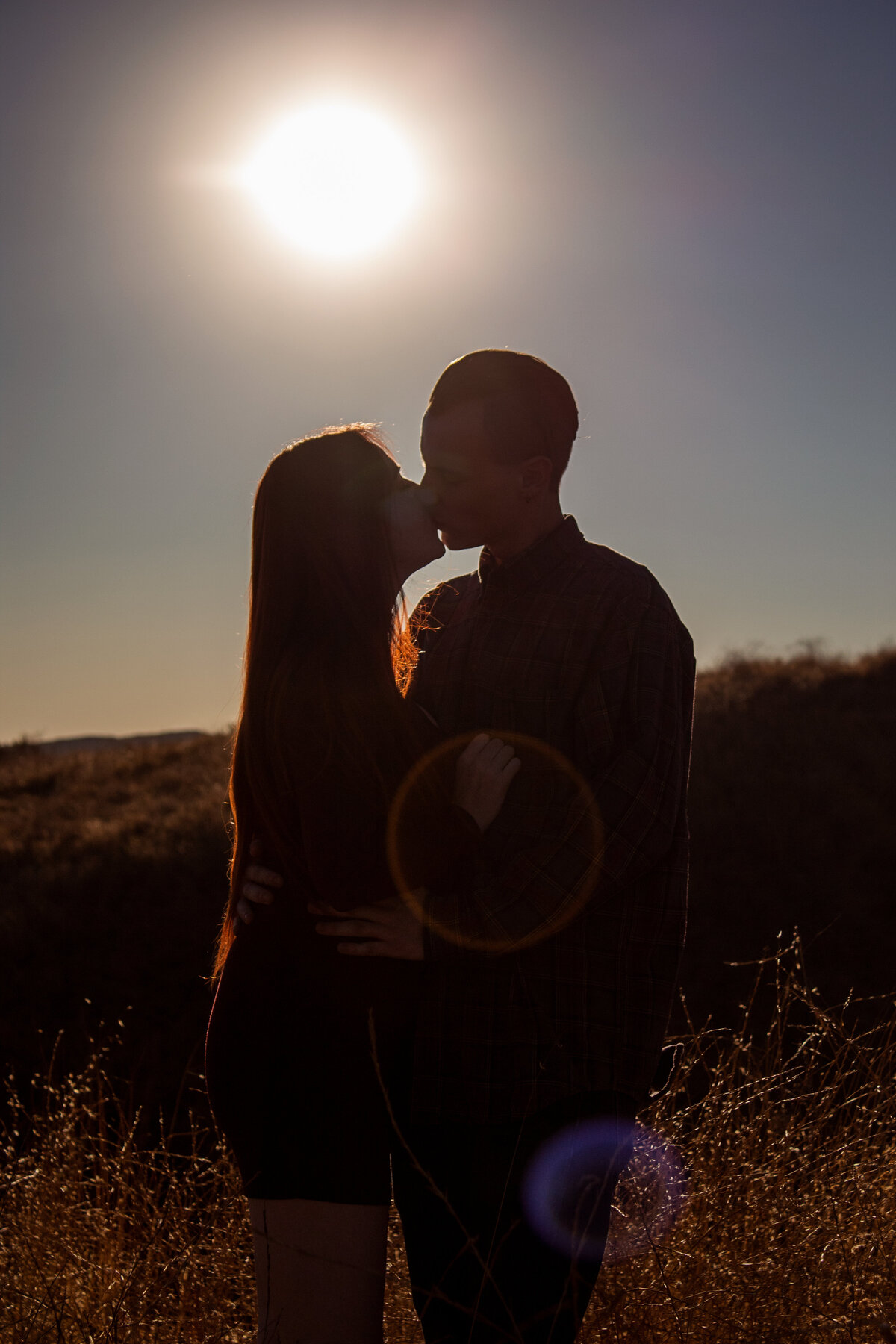 engaged couple cuddle in phoenix field