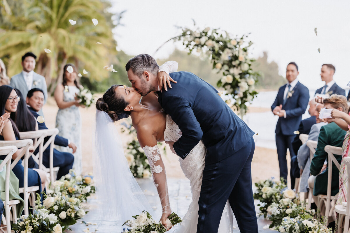 First kiss of bride and groom at Kualoa Ranch wedding ceremony