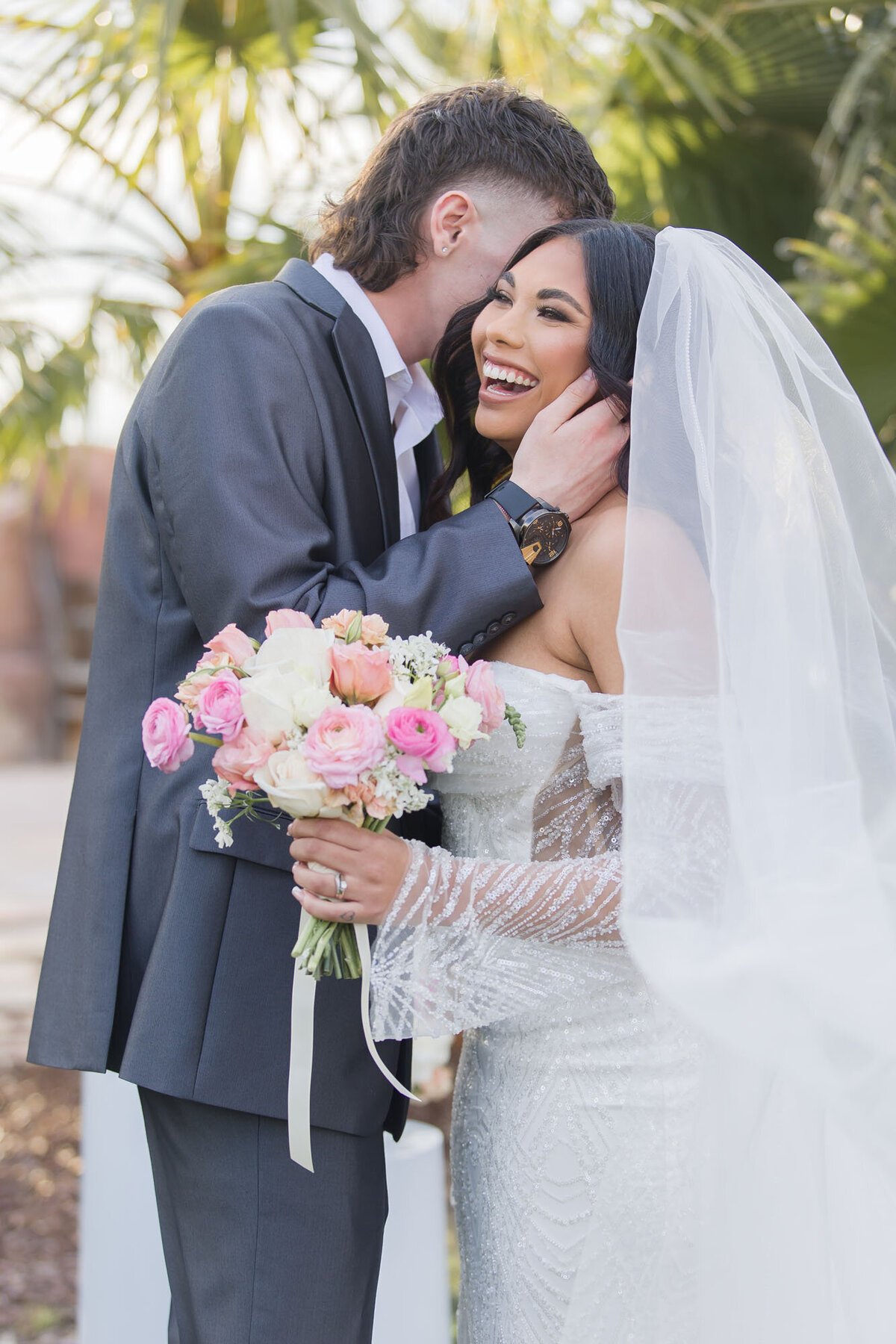 bride laughing at groom whispering to her on their wedding day