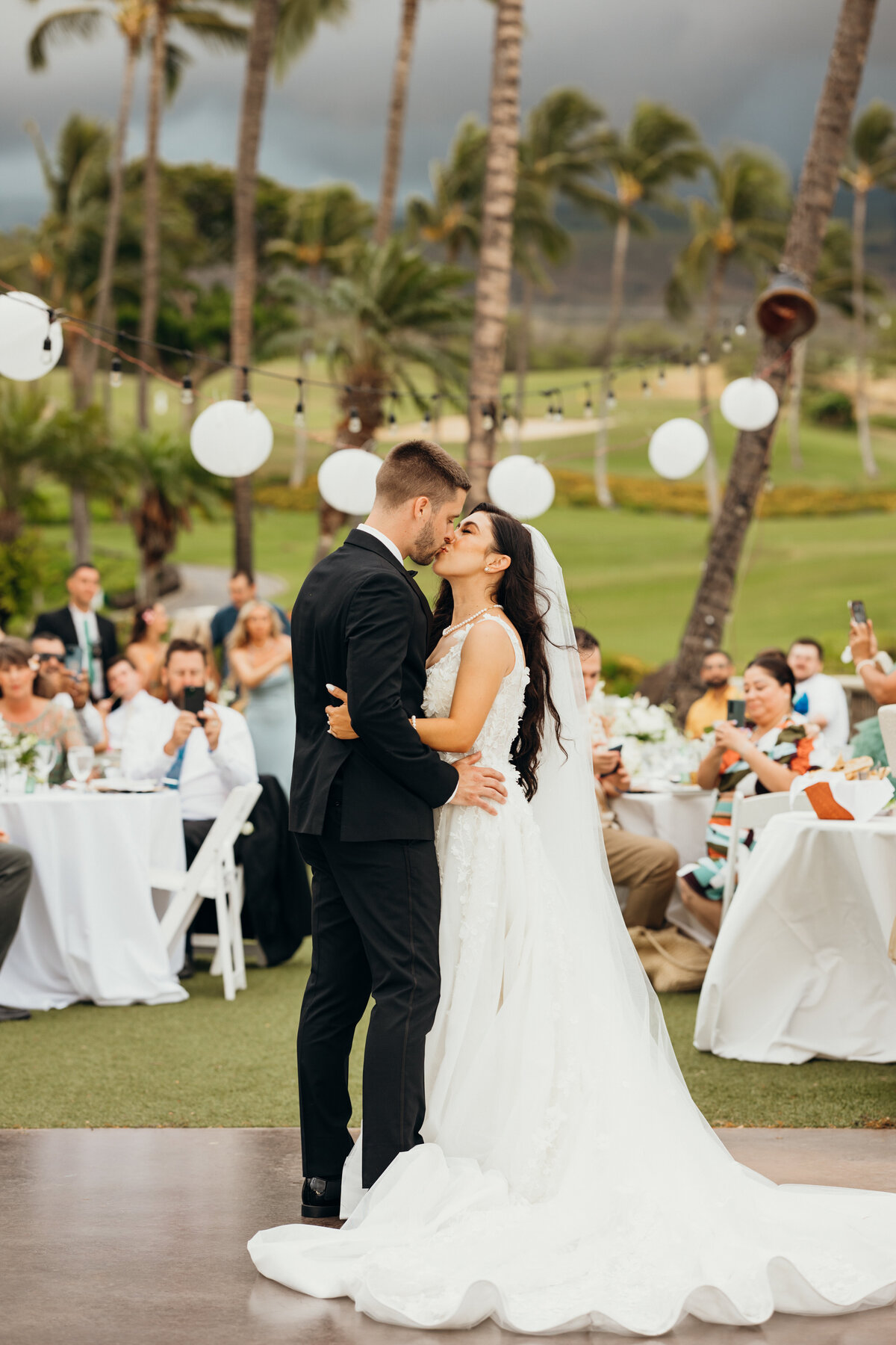 Maui Wedding Photographer captures bride and groom kissing during first dance as husband and wife