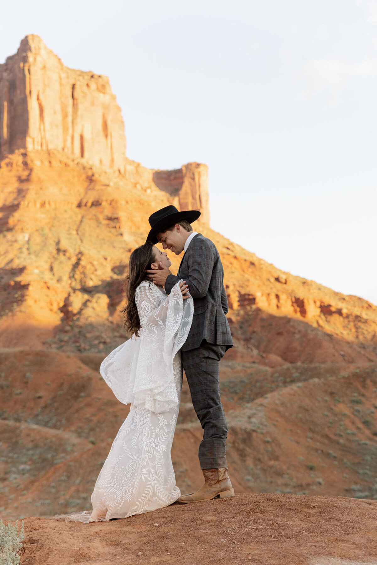 Bride and groom embracing in Moab by one of the top elopement photographers, Rachel.