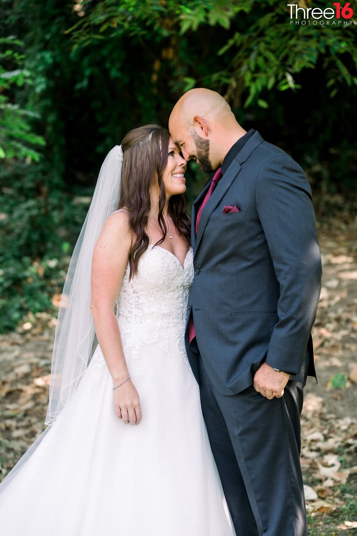 Bride and Groom touch foreheads as they gaze into each other's eyes and smile