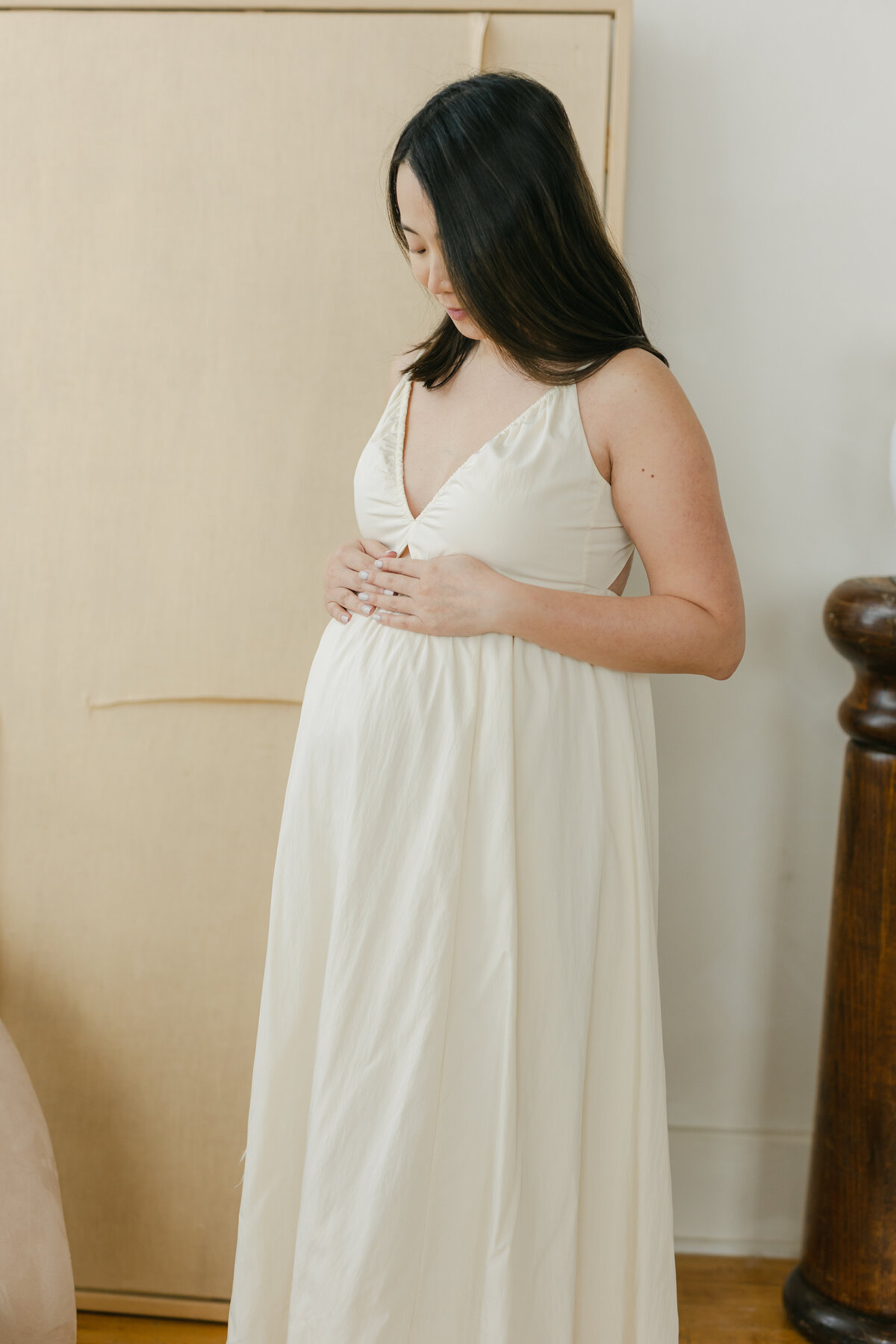 pregnant woman looking at belly by Toronto Maternity Photographer