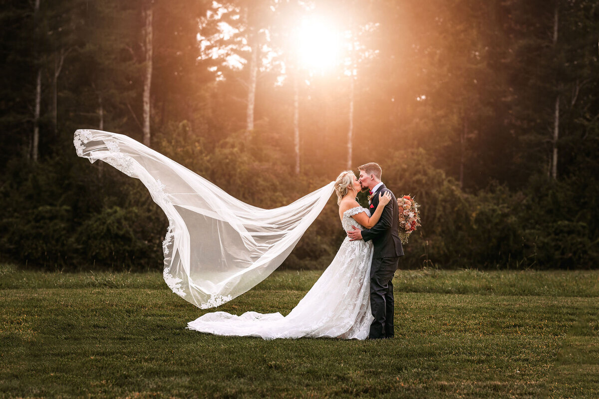floating vail and couple kissing in field at Sanborn Hill Farm by Lisa Smith Photography