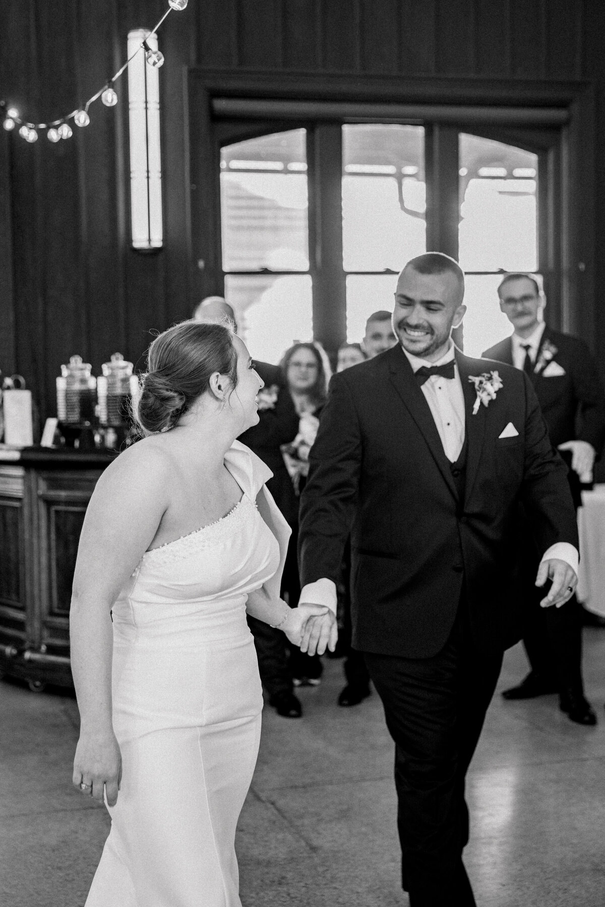 Black and white image of bride and groom entering their reception at the Bristol Train Station