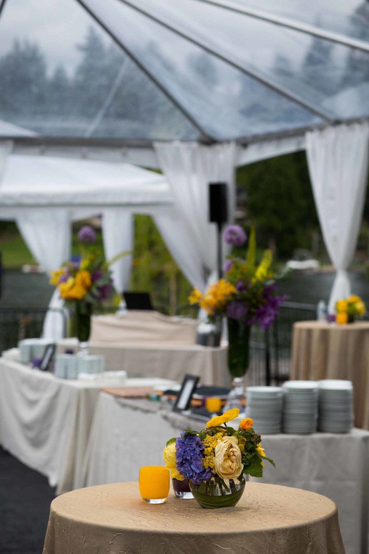 company launch party with yellow and purple flowers in clear party tent