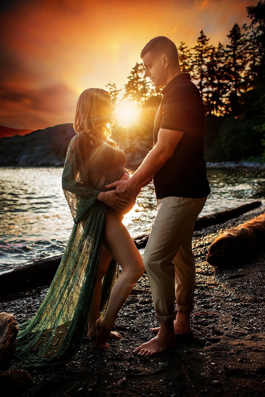 Expecting couple standing by the water during golden hour at Whytecliff Park in West Vancouver.