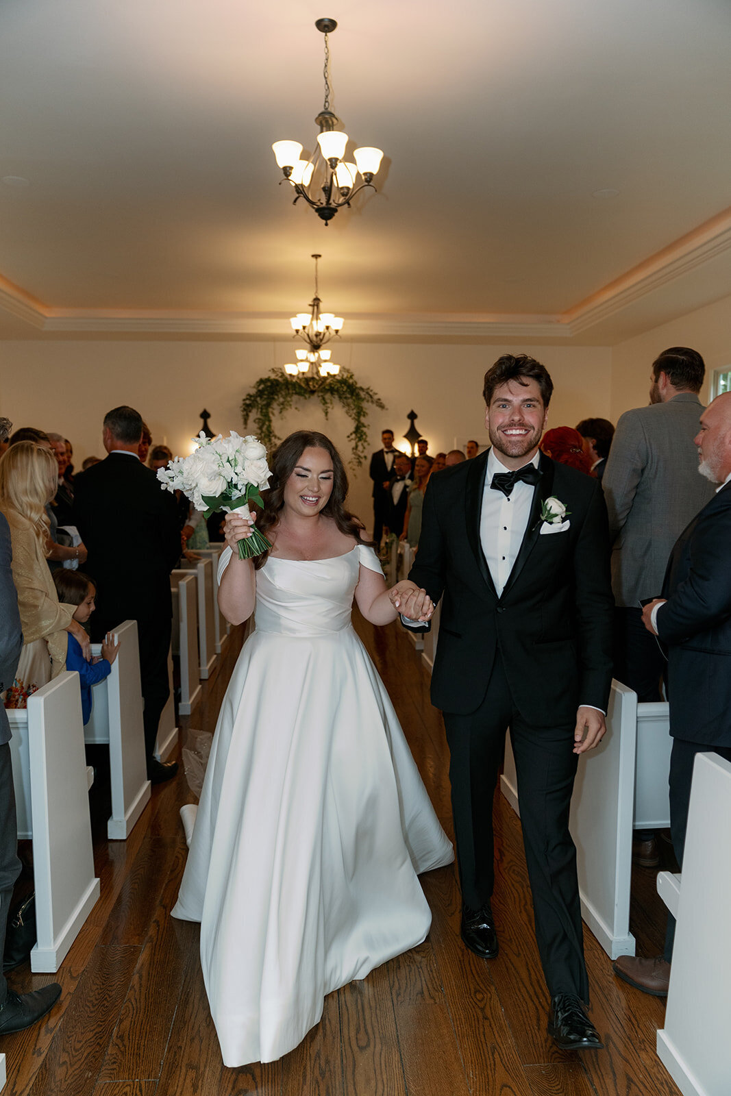 Bride and groom smiling as they walk down the aisle after their ceremony at The Morris Estate in Niles Michigan, captured by a Michigan wedding photographer.
