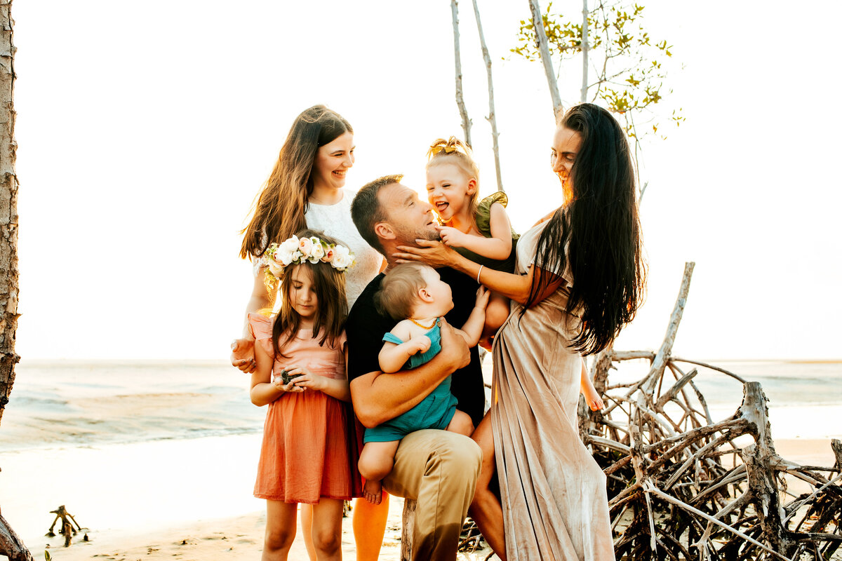 a family of 6 laughing having fun at a family beach session