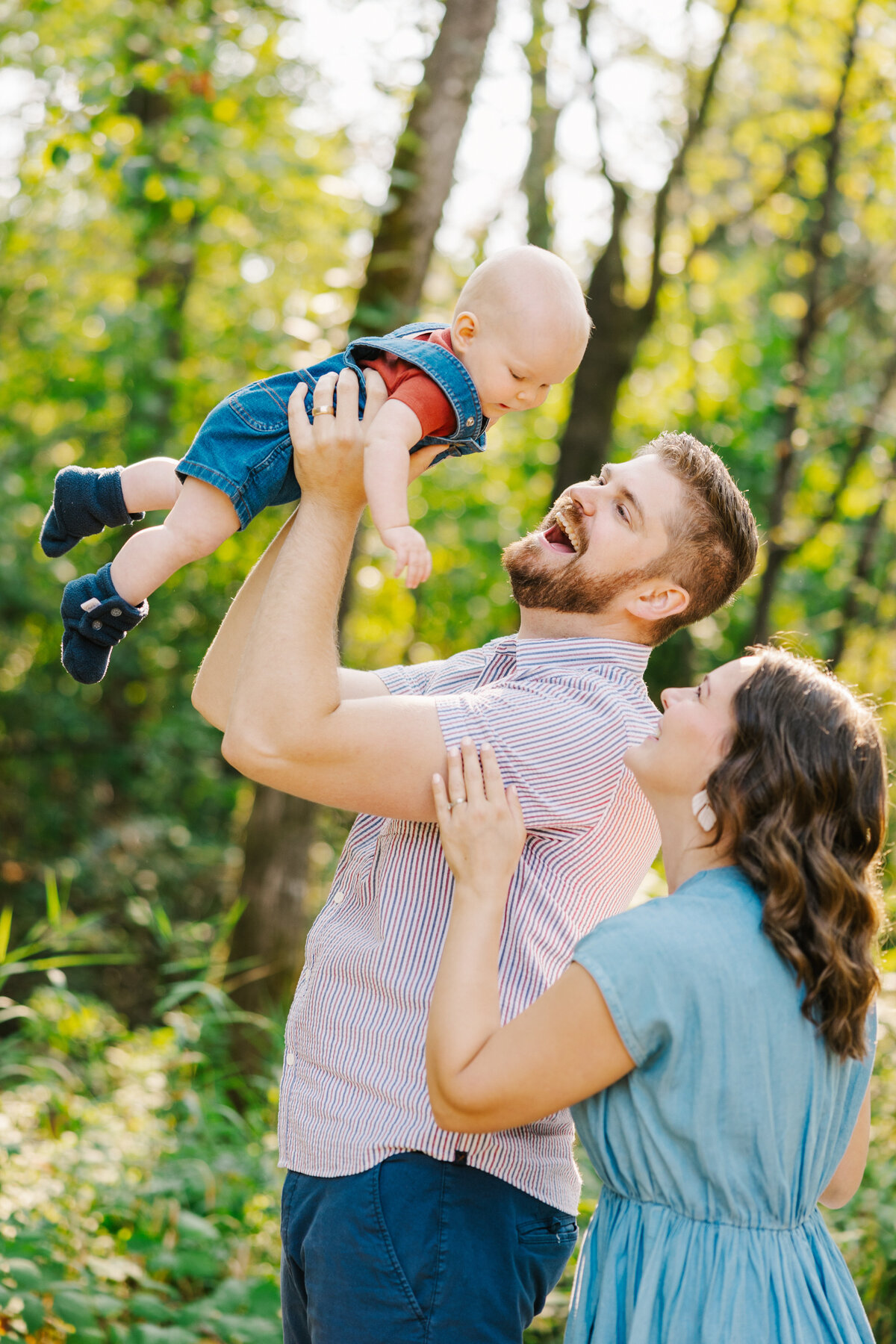 Mom and dad tossing baby in the air and smiling