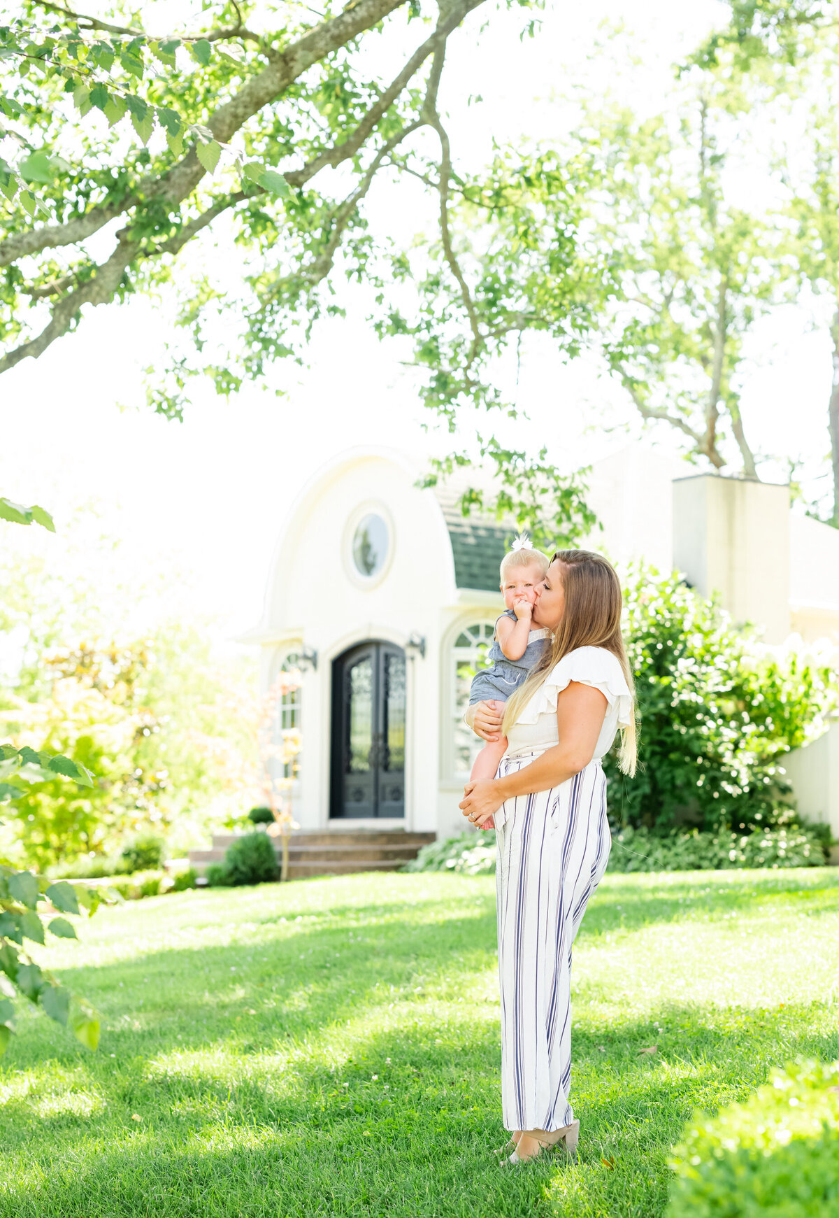 mom and toddler boy standing and kissing