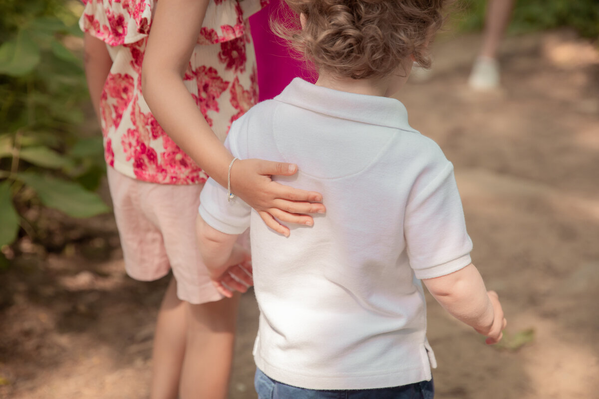 sister-helps-brother-walking-path
