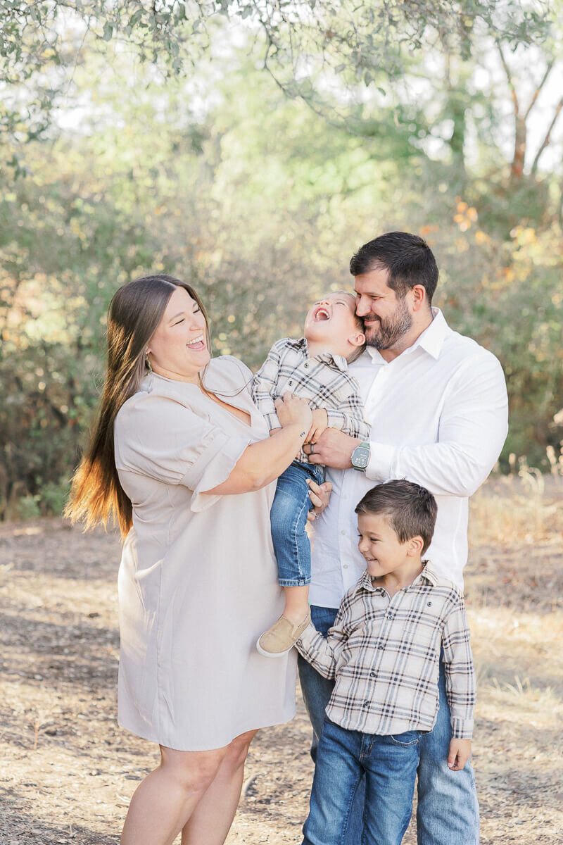 a family with two young boys tickles each other while candidly captured by an Austin family photographer.