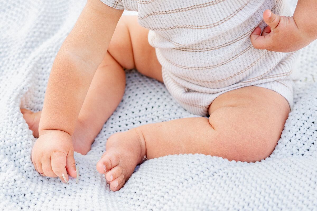A detailed shot of a baby’s chubby feet resting on a soft knitted blanket, capturing the innocence of childhood.