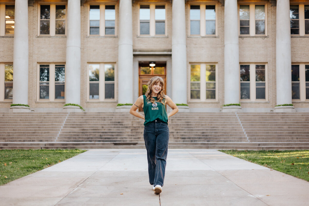 A smiling Colorado State University graduate enjoys a moment during her grad session in Fort Collins, Colorado.