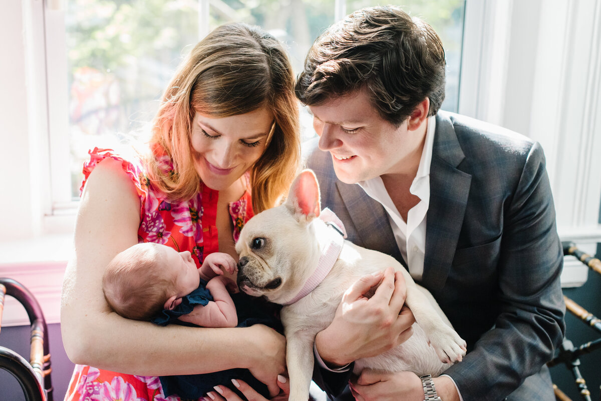 Two parents holding baby and family dog