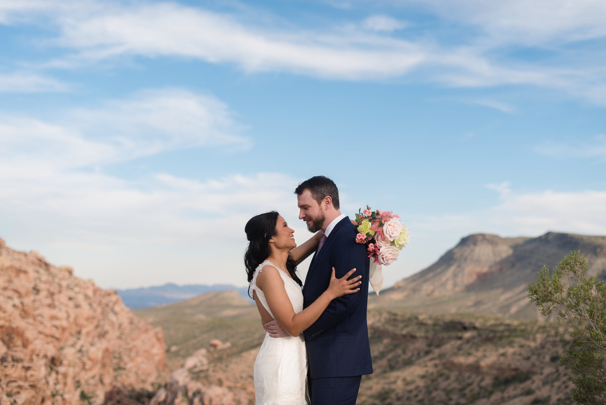 couple hugging with mountains behind at red rock canyon las vegas nevada wedding photographer