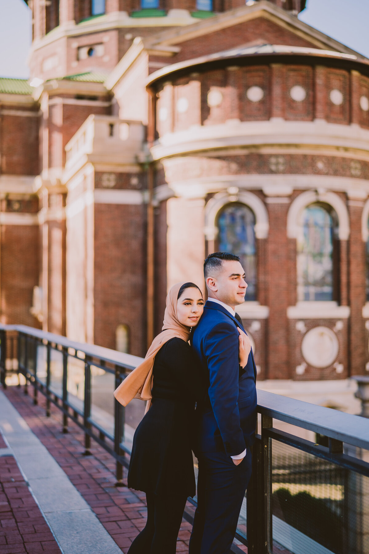 A couple standing at the ledge and check out the view from the top level at columbia university in nyc during their engagement session