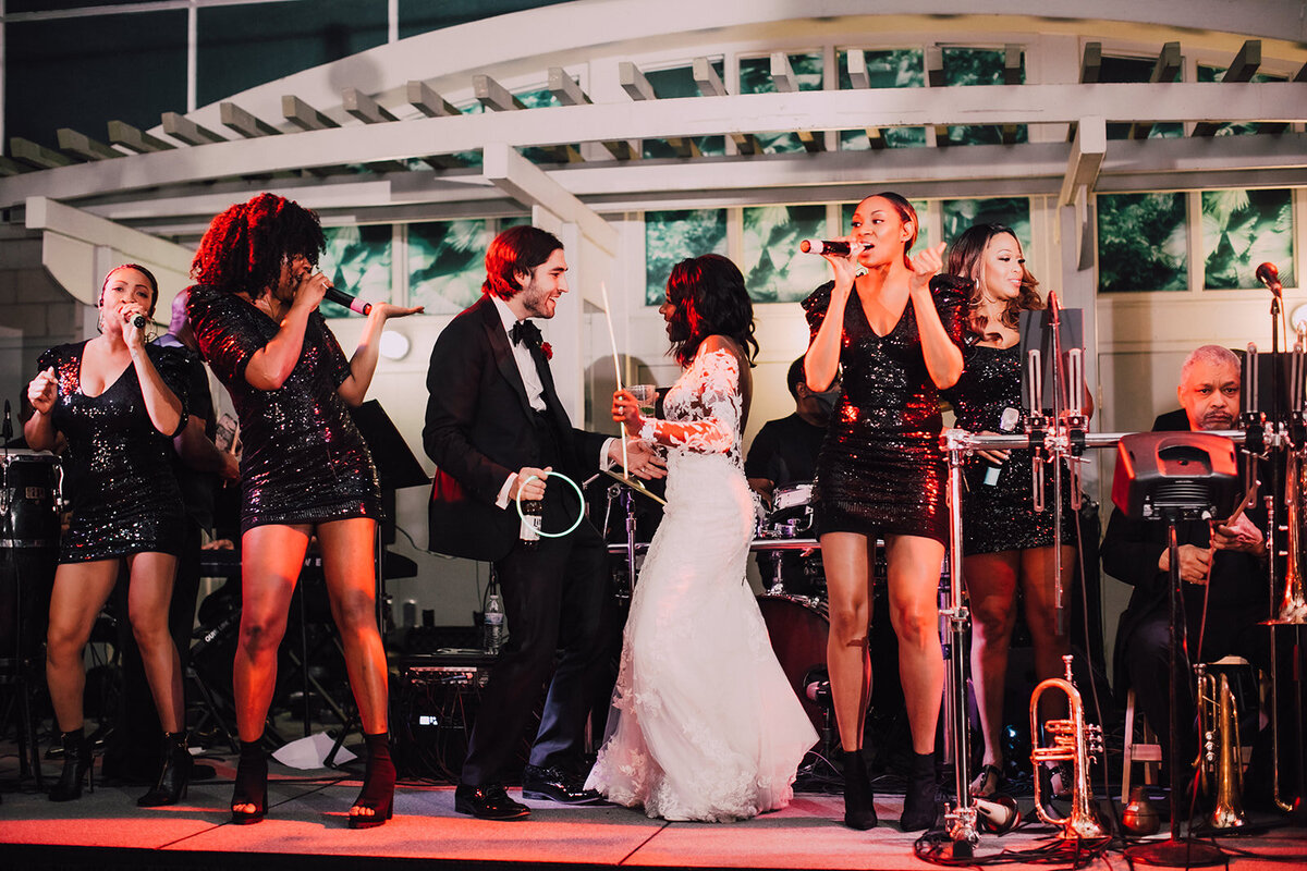 Bride and groom dance on stage with live band