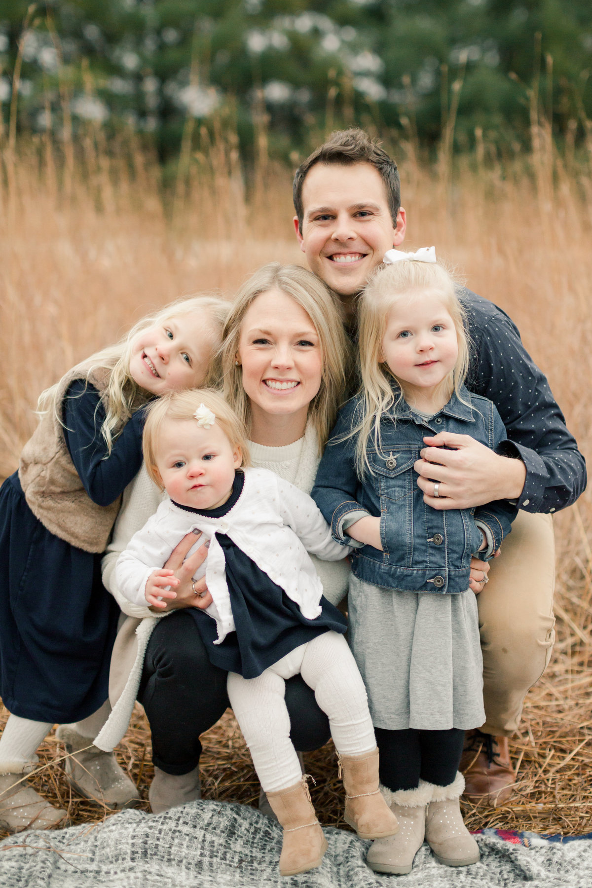 wild family of five cuddles in the gold grasses of oxbow park in rochester minnesota