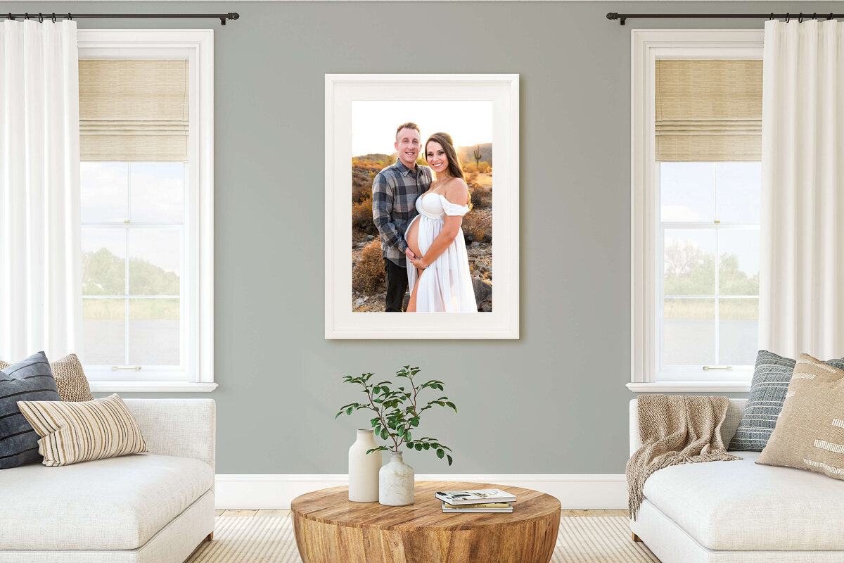 Framed maternity photograph taken by Cactus & Pine Photography, between 2 windows in living room