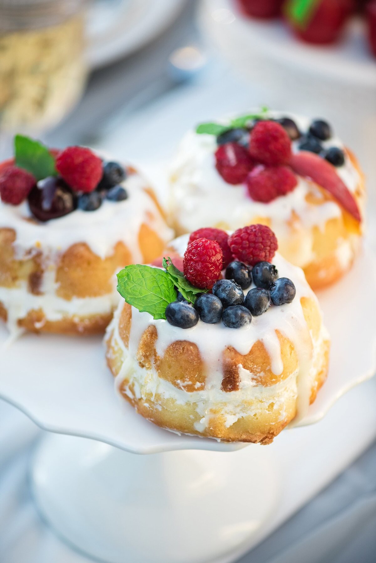 Cute mini bundt cakes with fresh berries and icing on top