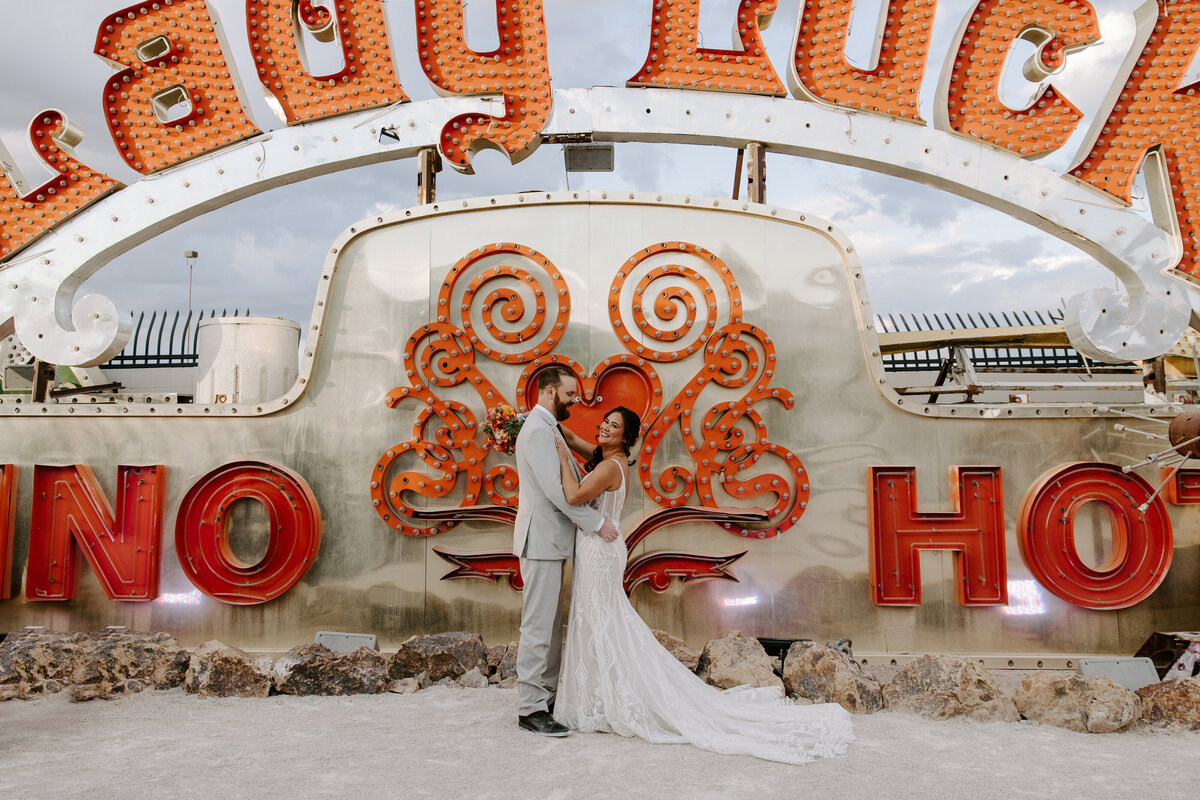 A couple poses in front of the Lady Luck sign at The Neon Museum.