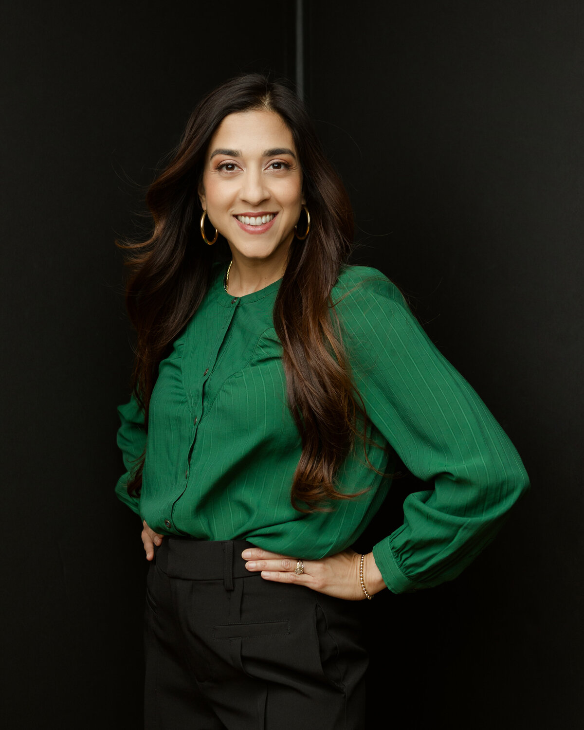 Smiling woman poses for headshot in green blouse