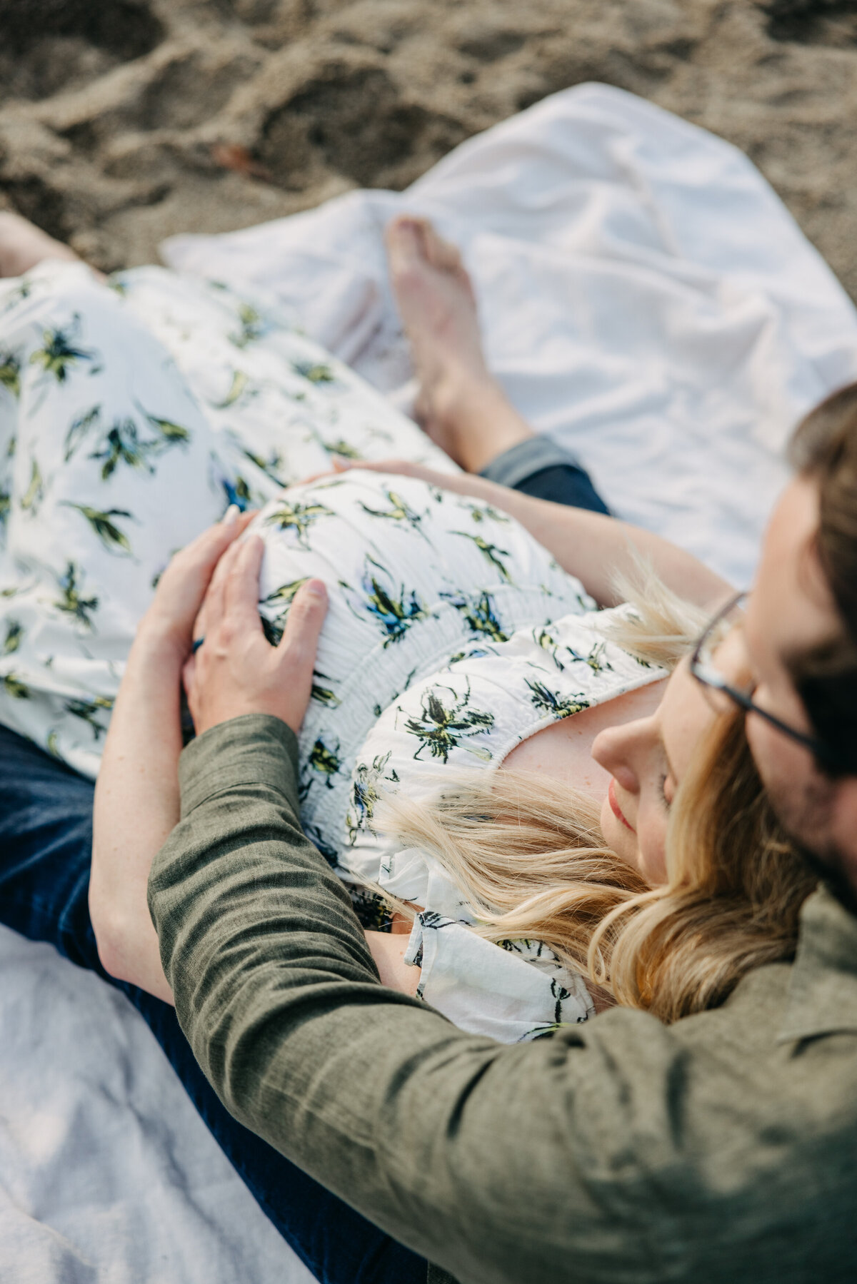 Pregnant mama and husband cradle bump on the beach in Malibu.