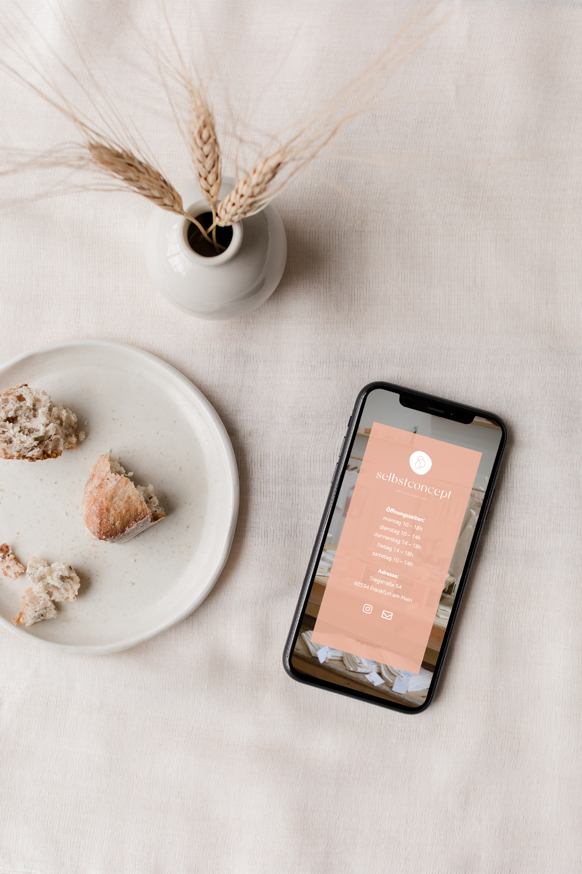 Flat-lay of an iphone next to some decorative items showing a landing page of a concept store