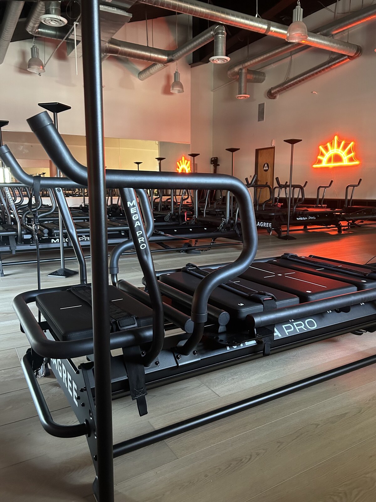 Detailed view of foot placement in black Megaformer strap using yellow grip socks at Rise Lagree Studio