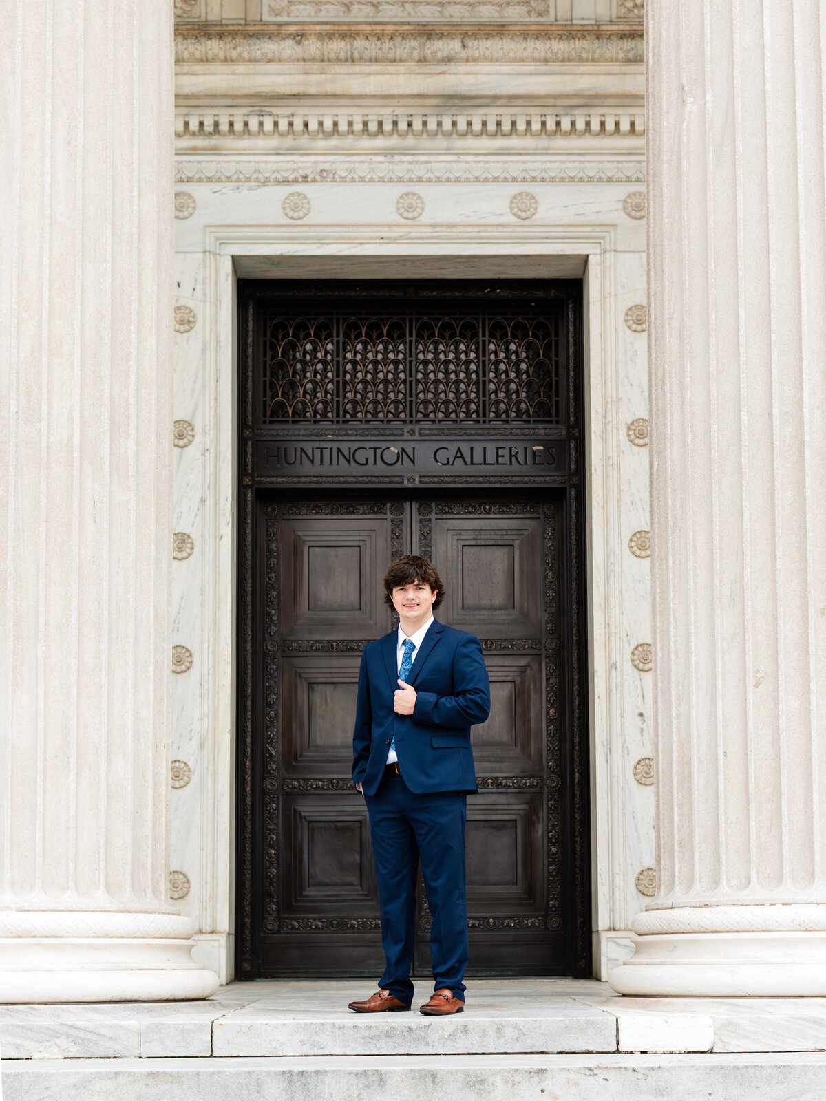 high school senior boy in blue suit posed at Cleveland Museum of Art for portraits