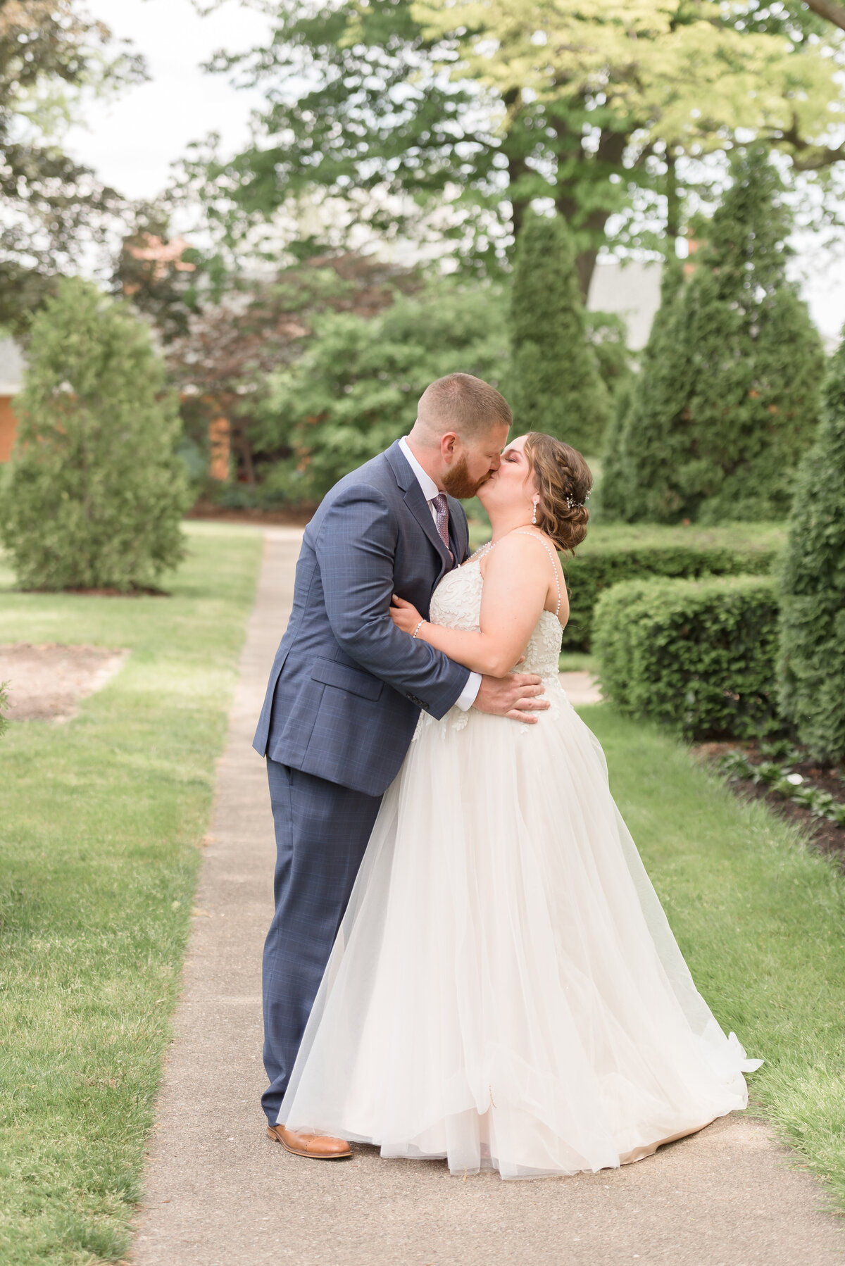 couple standing in walk way holding each other and kissing