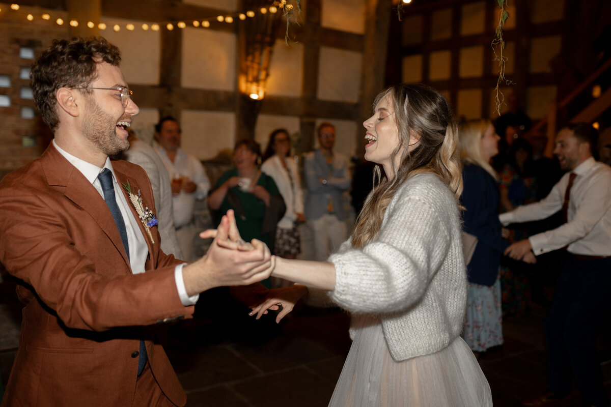 The bride and groom dance  in the Wool Barn at Frampton Court Estate, Gloucestershire