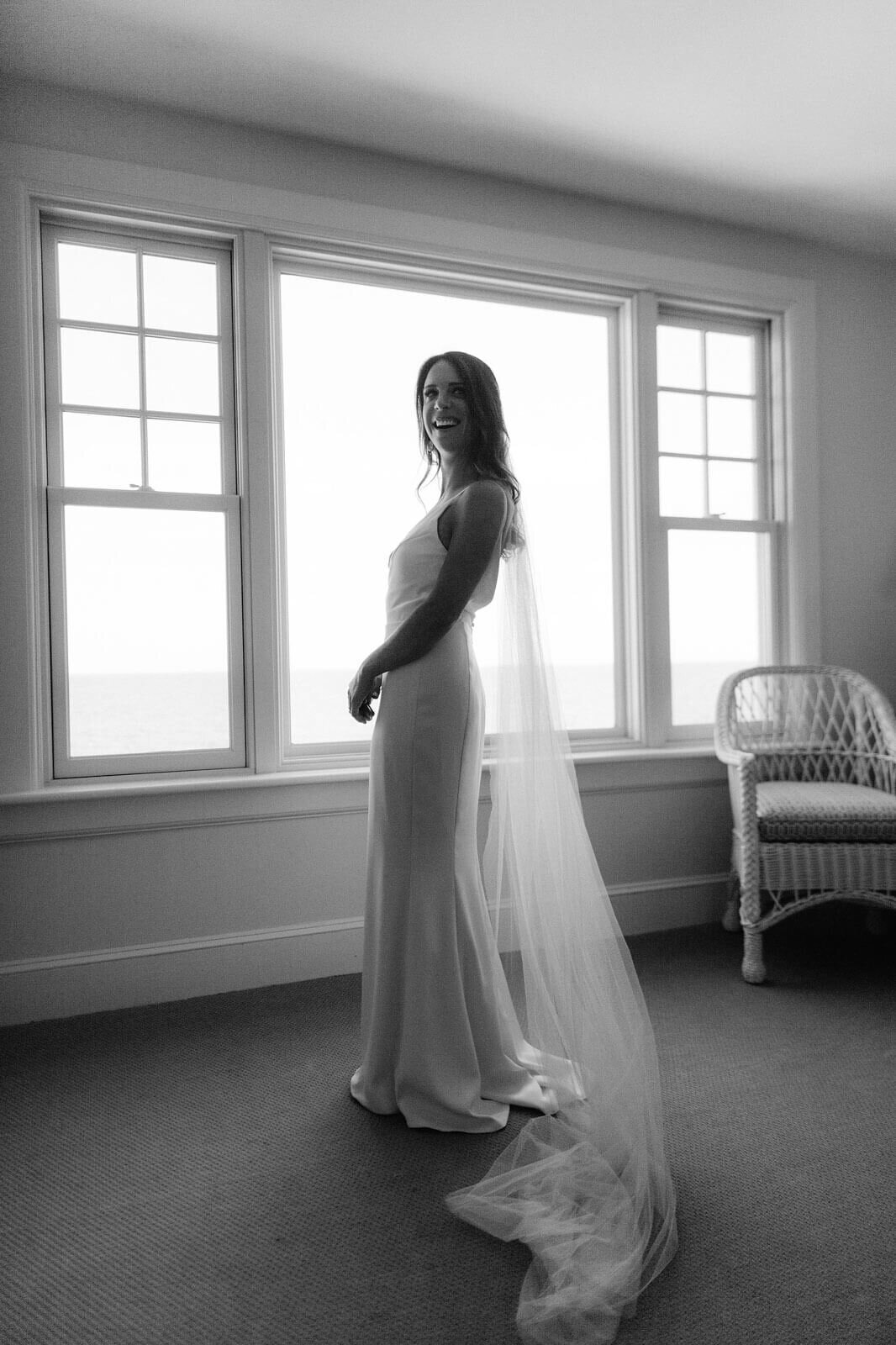 The bride is standing inside a room at Wianno Club, Cape Cod, MA.