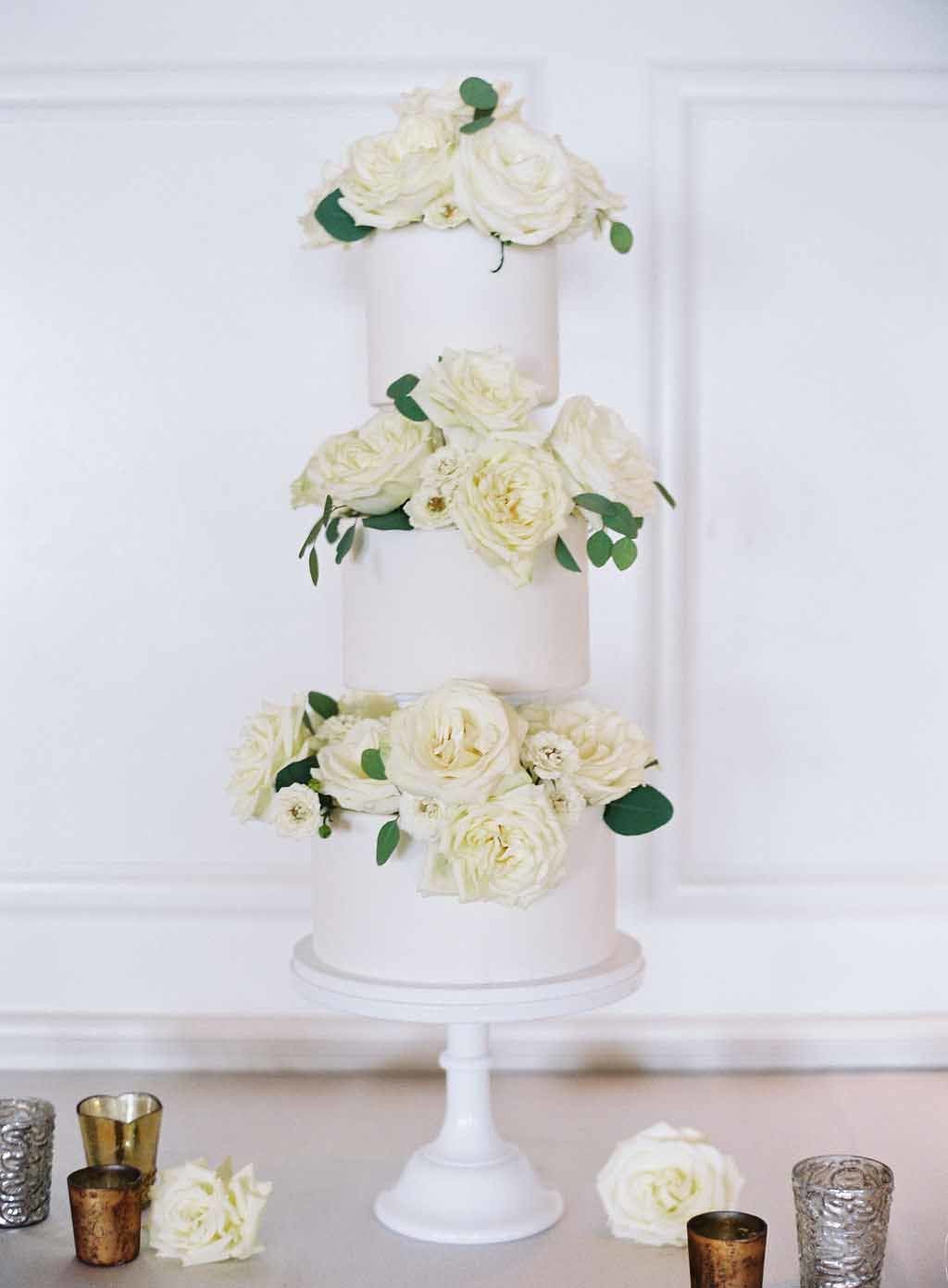 3 tiered white wedding cake with white roses